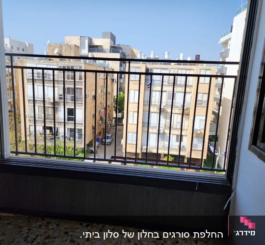 מעקה ברזל במרפסת עם נוף לבניינים